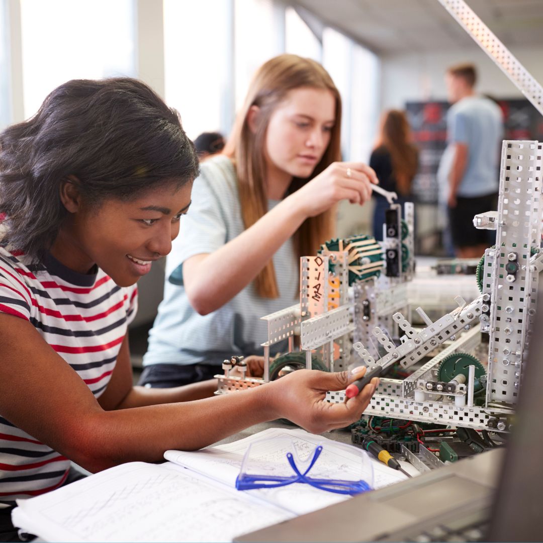 This image shows 2 teens building a robot.